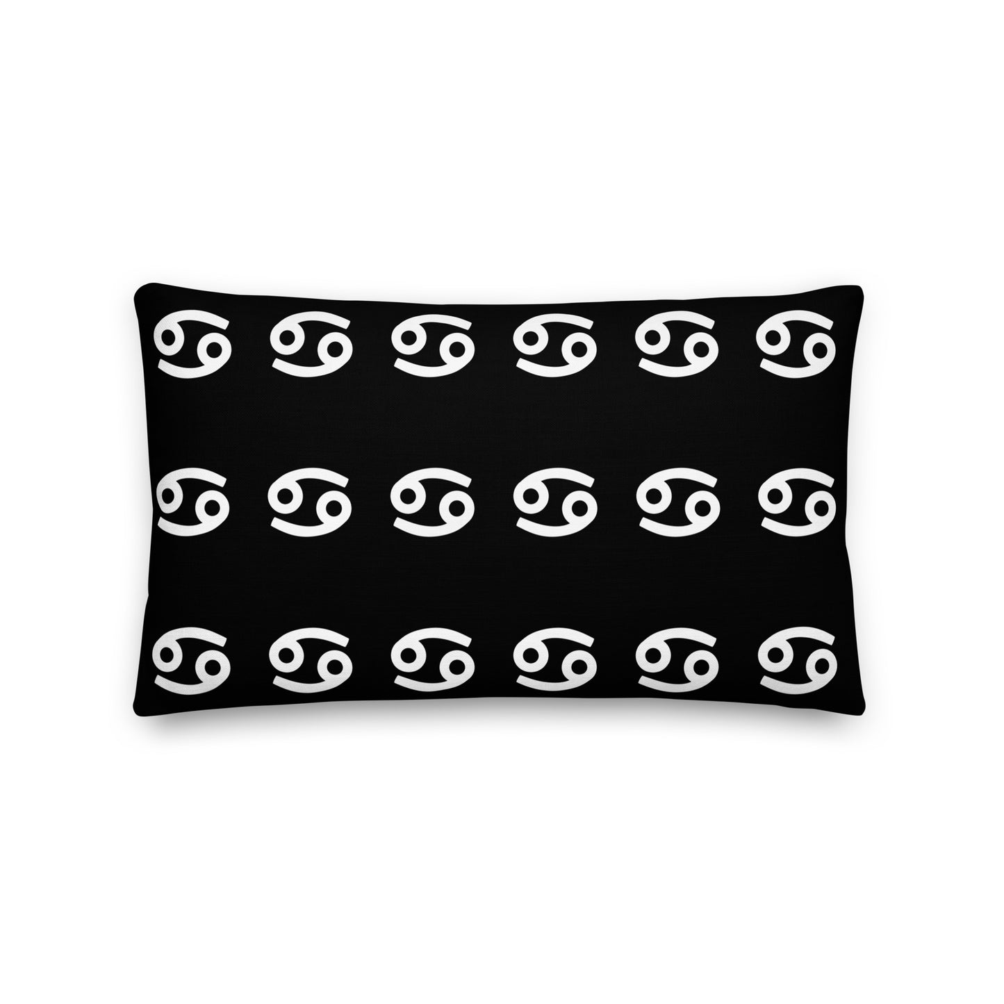 A luxury black square pillow with a pattern of white cancerian symbols, placed on a fluffy white surface.