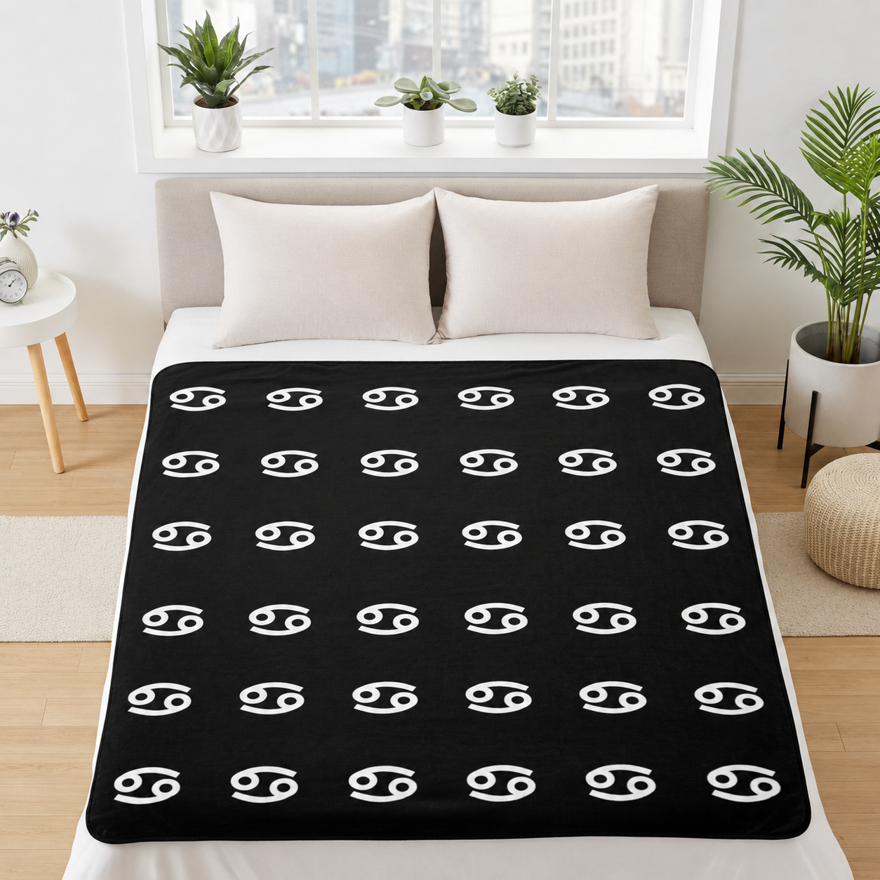 Black blanket with white cancerian symbol pattern on a bed in a bright room.