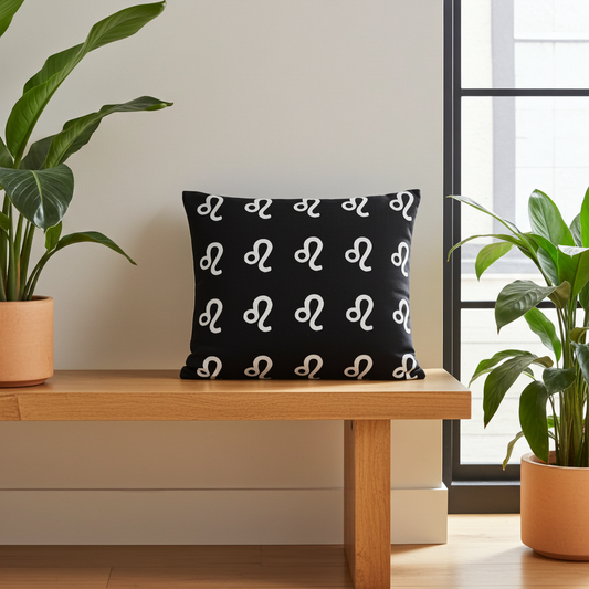 Black pillow with white cancerian patterns on a wooden bench in a room with plants