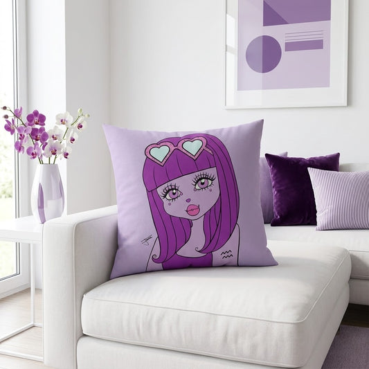 A square lavender throw pillow featuring a stylized cartoon illustration of a girl with purple hair and heart-shaped sunglasses, styled on a white sofa in a bright, modern living room.