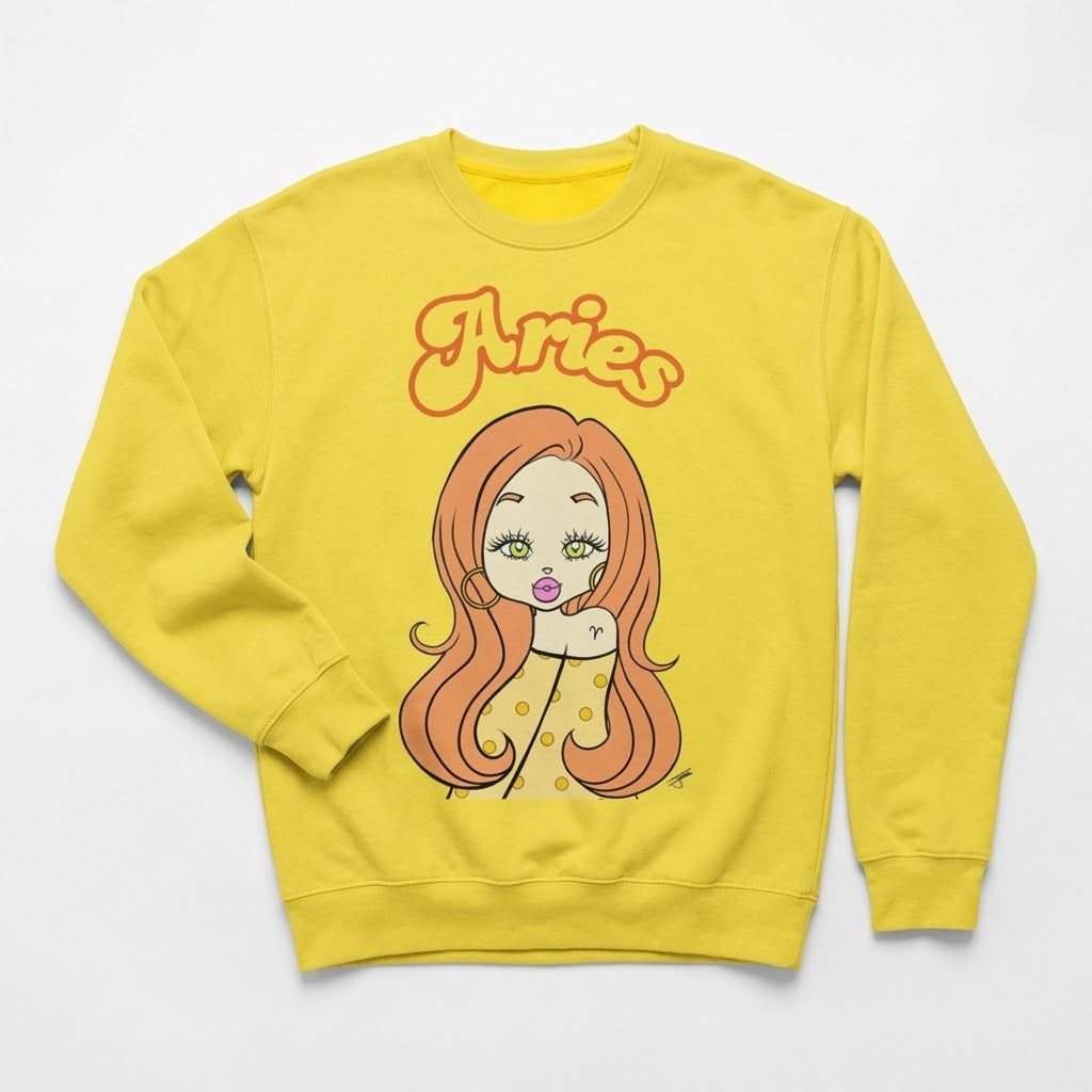 A bright yellow crewneck sweatshirt featuring a cartoon graphic of an Aries zodiac sign with orange hair and the word 'Aries' in orange script above it, displayed on a clean white background.