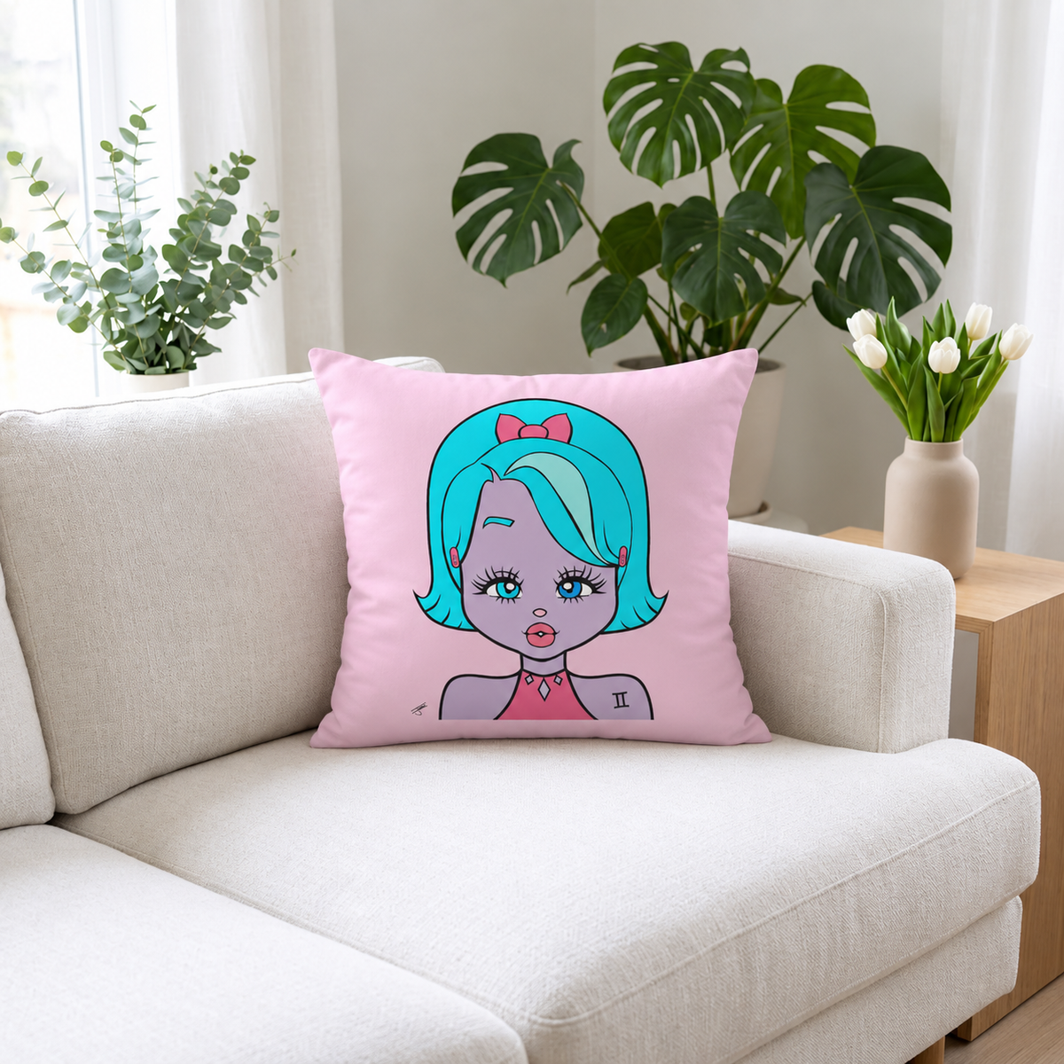 A square pink throw pillow with a cartoon illustration of a girl with turquoise hair and a pink bow, resting on a light beige sofa in a bright living room with potted plants and a vase of tulips.