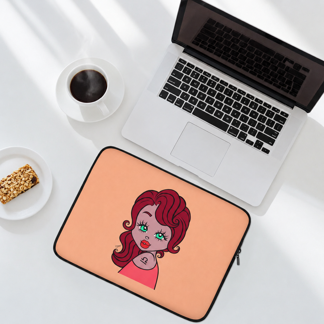 Laptop with a Libra character on a peach-colored mouse pad, next to a cup of coffee and snack.