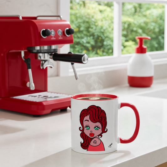 White mug with a red handle featuring a Libra character, filled with steaming coffee, next to a red espresso machine.