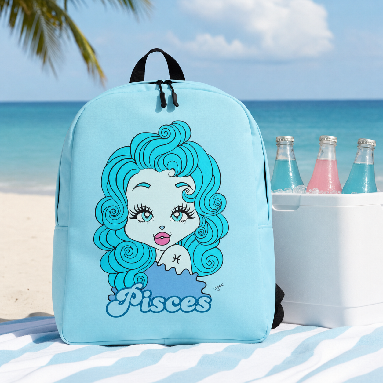 A light blue backpack with a Pisces zodiac character design and the word 'Pisces' printed on the front, set on a beach blanket with a cooler and bottles beside it, and the ocean and palm tree in the background.