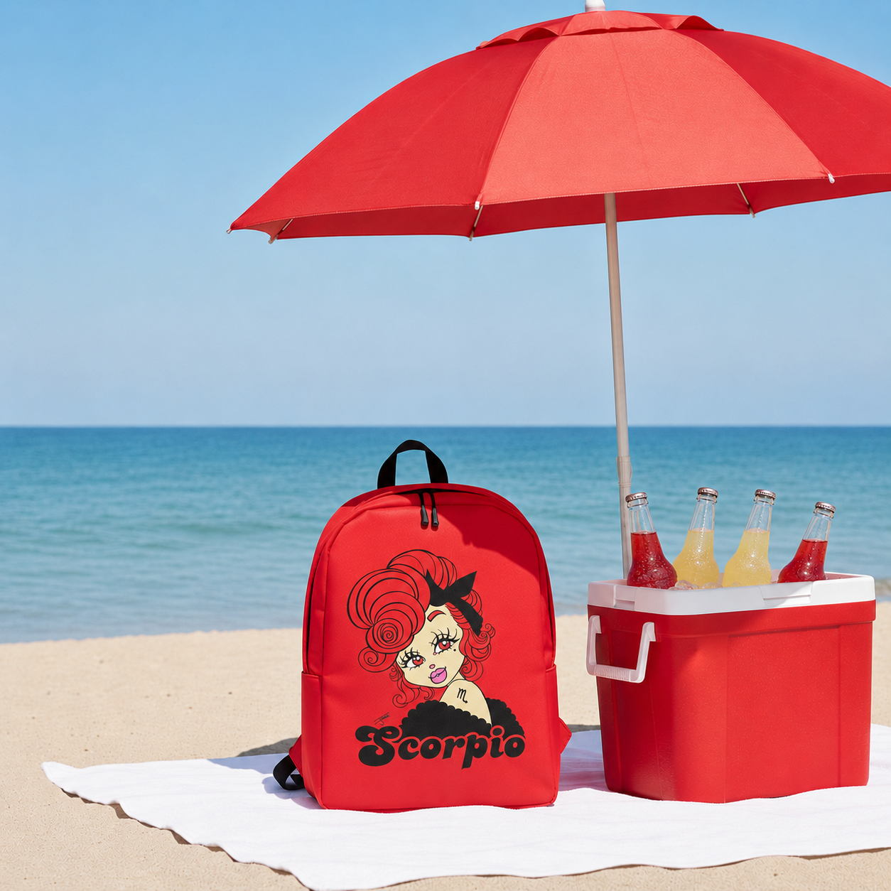 Red backpack with a scorpio character design, red umbrella, and cooler with drinks on a beach.