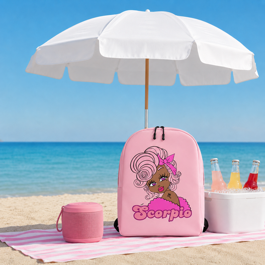 Pink backpack with a scorpio character design on a beach with an umbrella and drinks.
