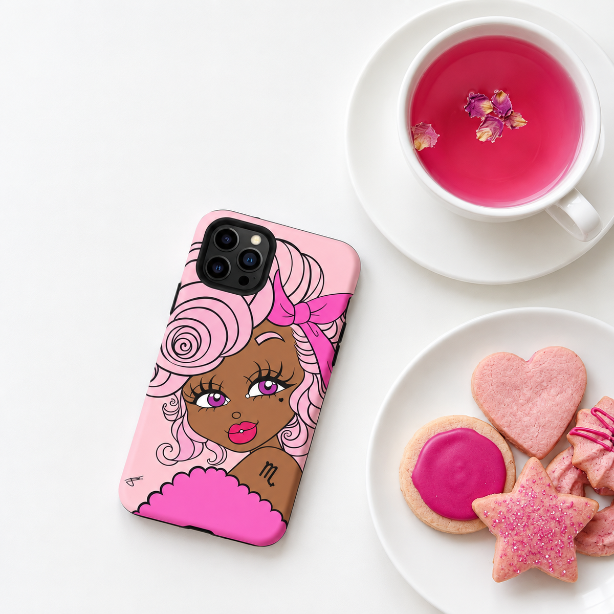 A pink phone case featuring a stylized illustration of a woman with pink hair and a pink bow, shown on a white phone. The case is styled in a flat-lay composition next to a cup of pink tea and a plate of pink cookies on a white background.