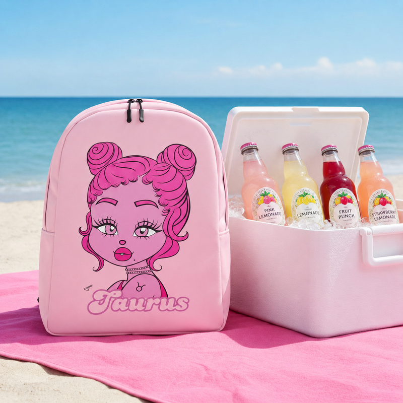 Pink backpack with Taurus design on a beach with a cooler of drinks.