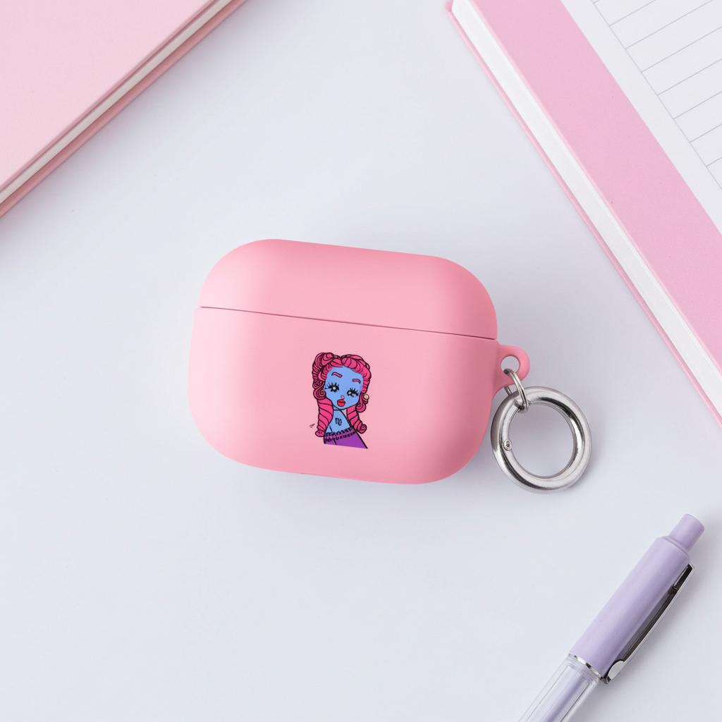 Pink airpod case with a Virgo character design on a white surface with a pen and notebook.