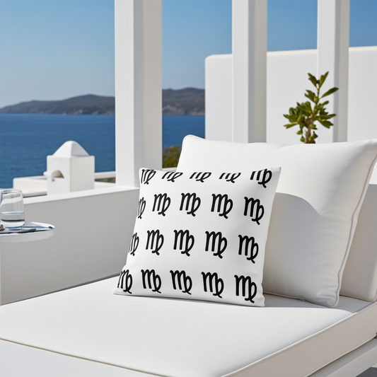 White cushion with black Virgo symbols on a white outdoor chair with ocean view