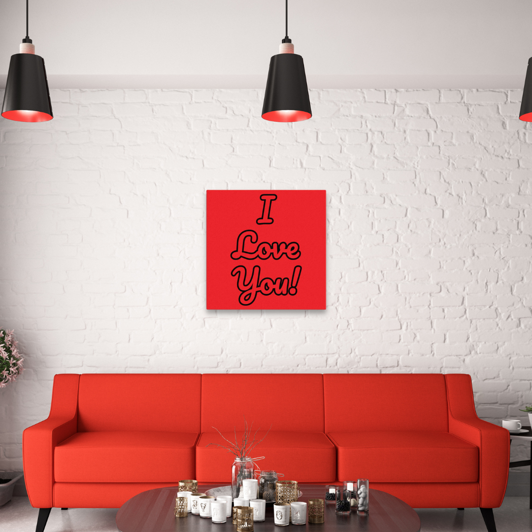 A red canvas wall art with the text 'I love you!' displayed on a white wall above a red couch, with black hanging lights and a white brick wall in the background.